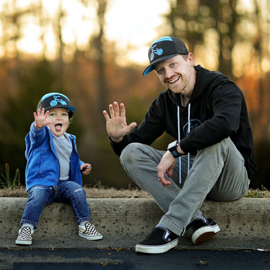 Shop online for snapback hats from LB Threads for baby, toddler, kid and adult. Dad and son models wearing matching LB Threads BMX hat, a black and blue 7-panel snapback trucker hat.