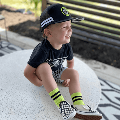 Toddler wearing the Otto Checkers or Wreckers hat, a snapback trucker hat with checkered under brim, white stripes and a pop of neon on a black snapback. A super rad hat! | LB Threads
