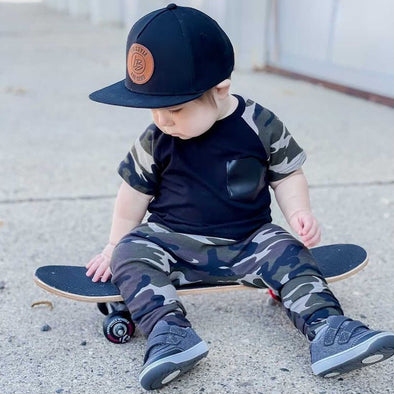 Toddler wearing black snapback hat on skateboard in a cool outfit | LB Threads snapback hat