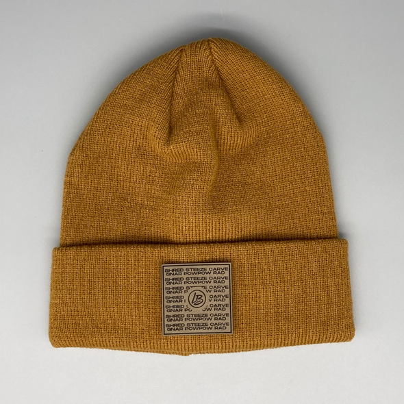 Shop online for beanies and snapback hats from LB Threads for babies, toddlers, kids and adults. Photo shows our Steezy Beanie, a warm, soft, black, tan or cream acrylic beanie with a colored leather snowboard lingo patch.