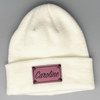 Shop online for beanies and snapback hats from LB Threads for babies, toddlers, kids and adults. Photo shows our Cream Custom Name Beanie, a warm, soft, cream-colored acrylic beanie with a leather engraved custom name patch attached with rivets.