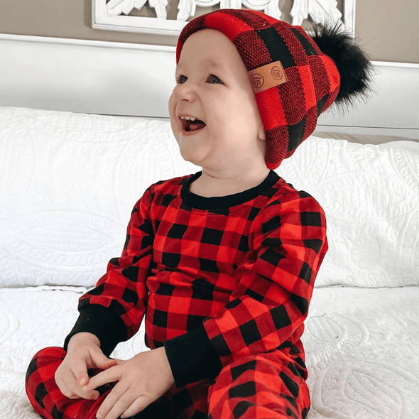 Shop online for beanies and snapback hats from LB Threads for babies, toddlers, kids and adults. Toddler model wearing the LB Threads Red Buffalo Pom Beanie, a cozy, soft red buffalo plaid topped with a black faux-fur pom, lined with super soft black minky fleece for extra warmth.