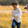 Shop online for snapback hats from LB Threads for baby, toddler, kid and adult. Toddler model wearing the LB Threads Jackson hat, a classic, charcoal herringbone-patterned, wool-blend snapback hat with a brown leather, rectangular LB Threads Big Style, Big Send patch.